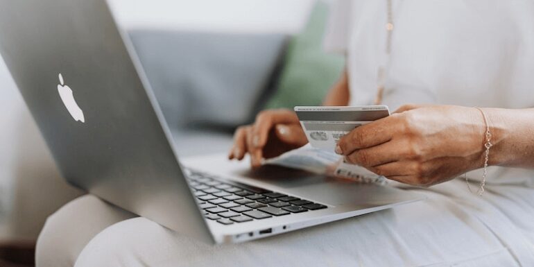 Woman with MacBook and credit card.