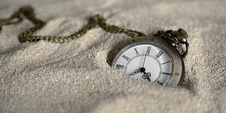 A pocket watch in the sand.